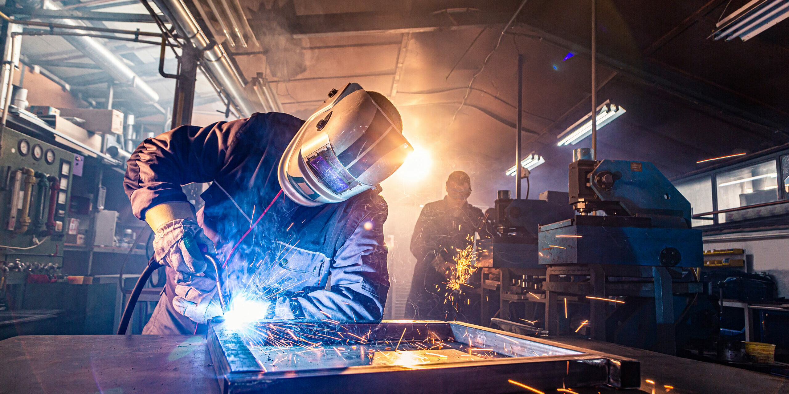 The,Two,Handymen,Performing,Welding,And,Grinding,At,Their,Workplace The,Two,Handymen,Performing,Welding,And,Grinding,At,Their,Workplace