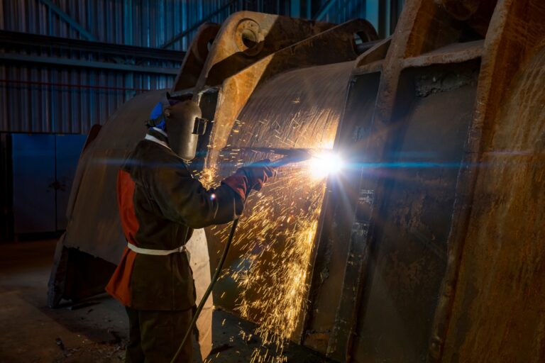 Worker,With,A,Mask,Welding,An,Excavator,Shovel,In,A heavy machinery welding repair