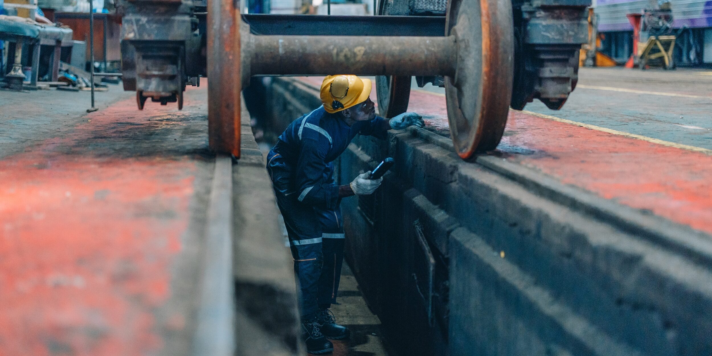 Rail,Maintenance,Technician,Use,Flashlight,To,Examine,Wheel,Assembly,Of